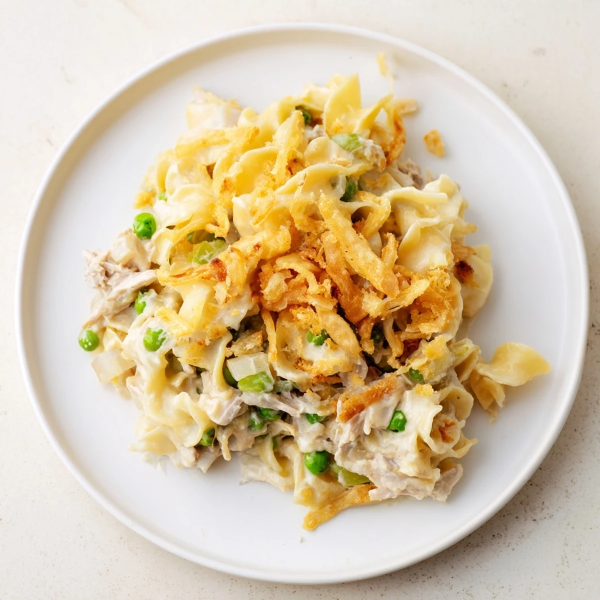Golden, bubbly Creamy Tuna Noodle Casserole with a crispy onion topping, perfect for a family dinner.