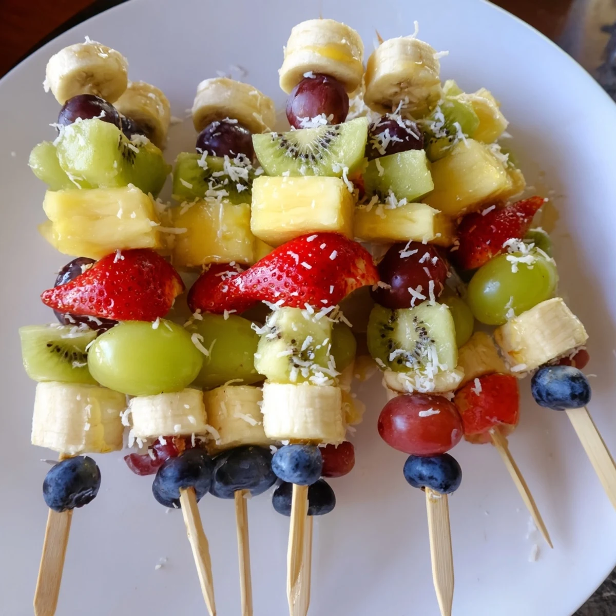 Bright and attractive display of Easy Festive Fruit Kabobs, piled high on a serving platter for any occasion.