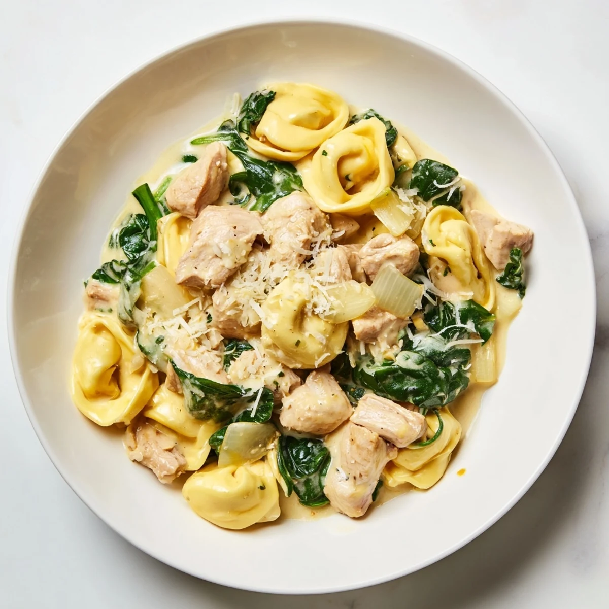 A close-up shot of Creamy Chicken and Spinach Tortellini, showing the perfectly wilted spinach and chicken.