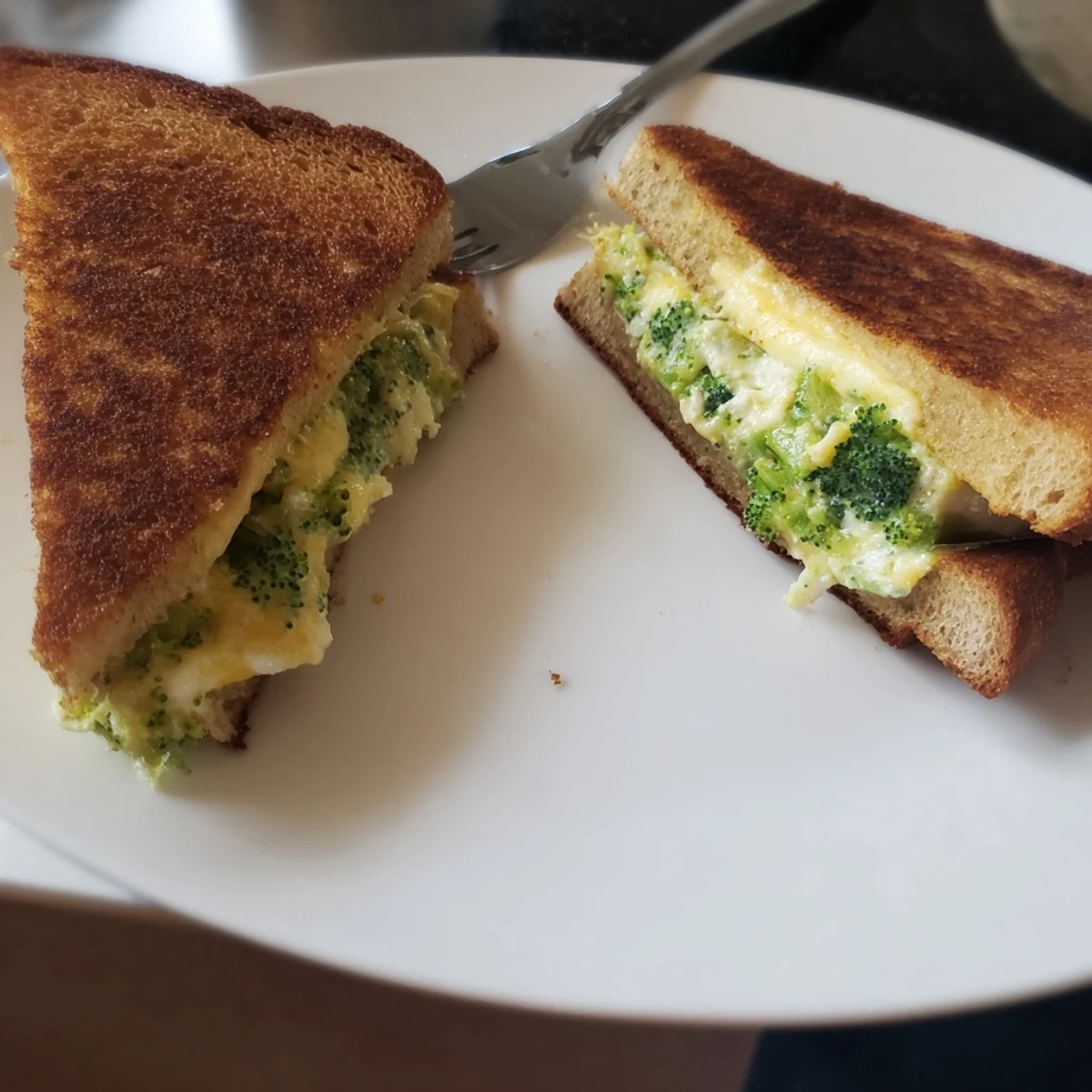 Air Fryer Broccoli Cheddar Stuffed Grilled Cheese with melted cheese oozing from crispy bread.