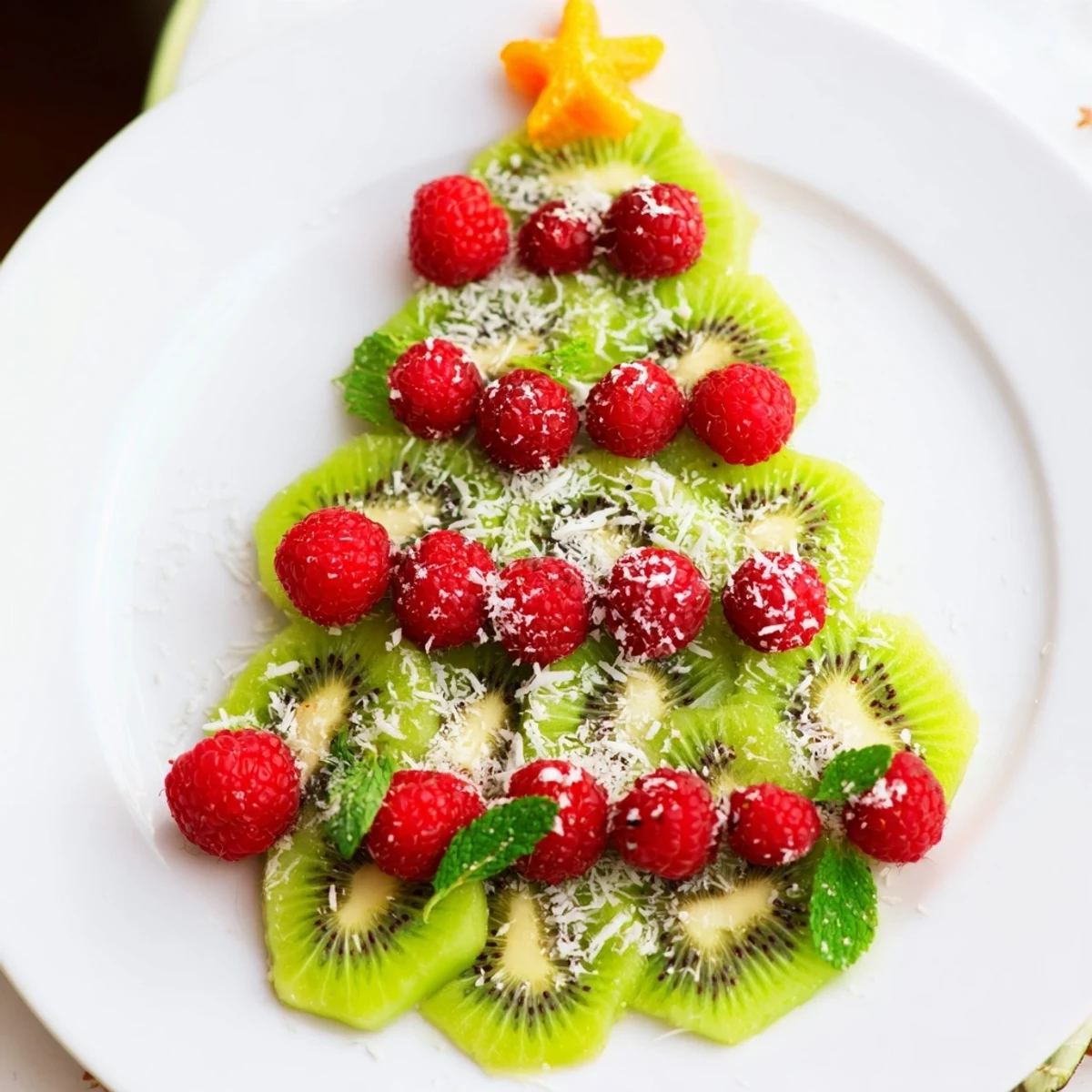 Fresh kiwi and ruby-red raspberries make this Kiwi and Raspberry Christmas Tree Fruit Plate festive.