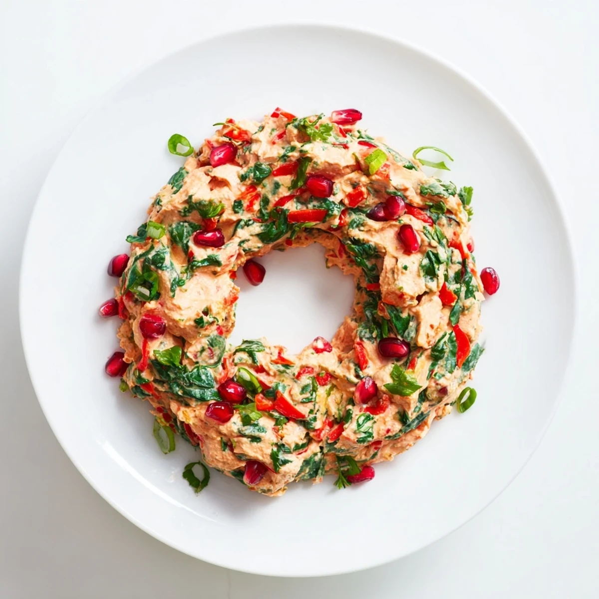 Festive Red Pepper and Spinach Dip Wreath, a creamy appetizer shaped on a platter and garnished with parsley, ready to serve.