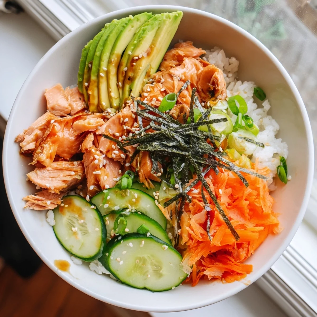 A beautifully arranged Japanese-Style Salmon & Chicken Rice Bowl, showcasing colorful fresh veggies and tender proteins.