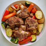 A close up of flavorful Jordanian Zarb reveals succulent meats and roasted vegetables, beautifully cooked.
