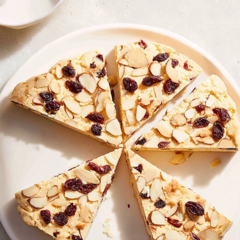 Golden, flaky Cherry Almond Shortbread Wedges, baked till crisp, dotted with cherries, and topped with almonds.