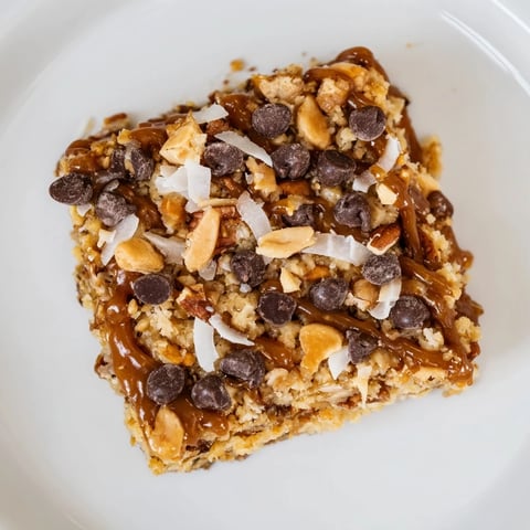 Golden-brown 7-Layer Magic Bars with a shimmering salted caramel drizzle, ready to serve!