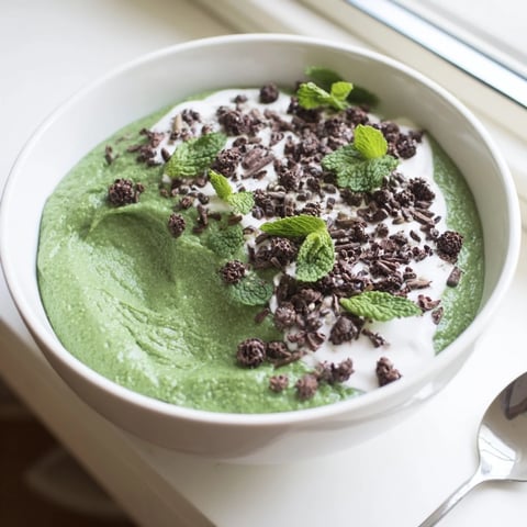 A layered serving of Grinch Green Mint Matcha Breakfast Chia Pudding, featuring fresh berries and mint.