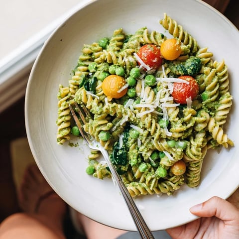 One-Pot Creamy Pesto Pea Protein Pasta: A steaming bowl with vibrant green pesto and perfectly cooked pasta.
