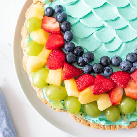 Sweet Under the Sea Mermaid Tail Fruit Pizza, vibrantly decorated with fresh fruit on a sugar cookie base.
