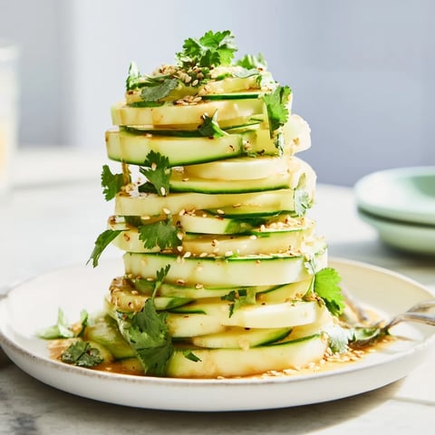 A vibrant stack of Jicama and Cucumber Slices, drizzled with a zesty lime chili dressing.
