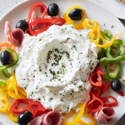 The Medusa Curls platter features spiraling meats and colorful peppers around a creamy dip head.