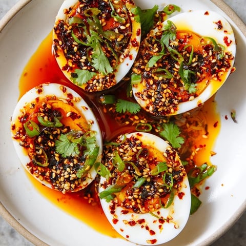 Chili oil eggs, glistening with a vibrant red chili oil, offer a burst of flavor for breakfast.