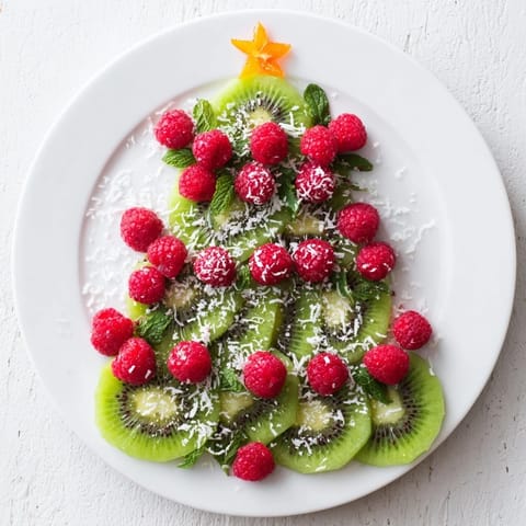 Enjoy the bright colors of this healthy Kiwi and Raspberry Christmas Tree Fruit Plate at your holiday gathering.