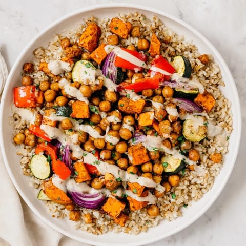 This wholesome Roasted Chickpea Buddha Bowl features fluffy rice, creamy tahini, and flavorful roasted ingredients.