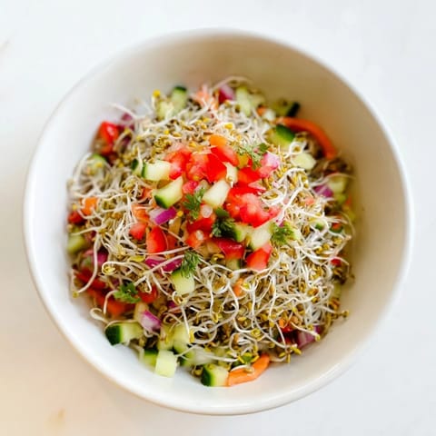 Close-up of a fresh Sprouted Seed Salad featuring radish sprouts, grated carrot, and chopped cilantro, served in a white ceramic bowl.