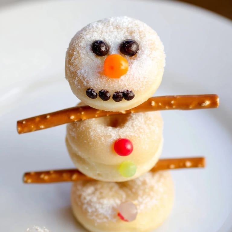 Homemade mini donut snowman skewers, a festive dessert with pretzel arms, great for kids.