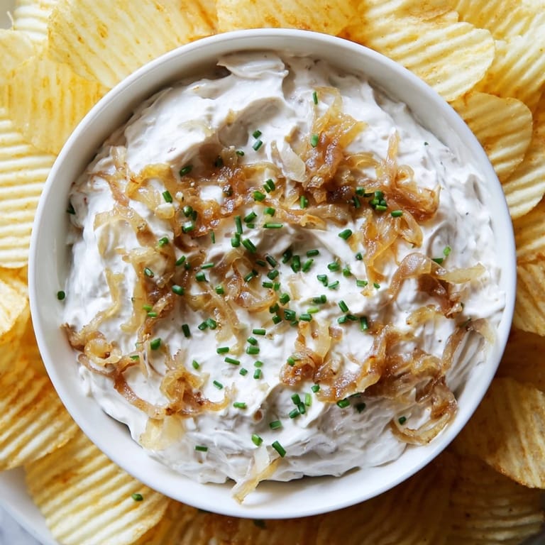 A close-up of potato chips with onion dip, perfect for snacking and gatherings.