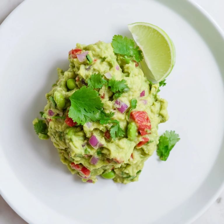 A close-up of creamy Edamame Guacamole: a vibrant, flavorful appetizer bursting with fresh ingredients.