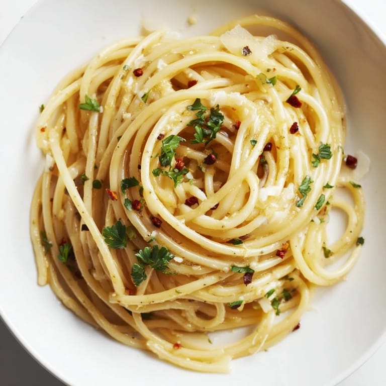 Close-up of golden Aglio e Olio Express Pasta, a simple dish with chili flakes and garlic.