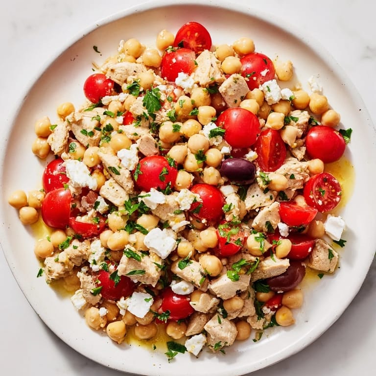 A fresh bowl of Mediterranean Chickpea Chicken Salad with crisp cucumber, briny Kalamata olives, and vibrant parsley, perfect for a light and healthy summer lunch.