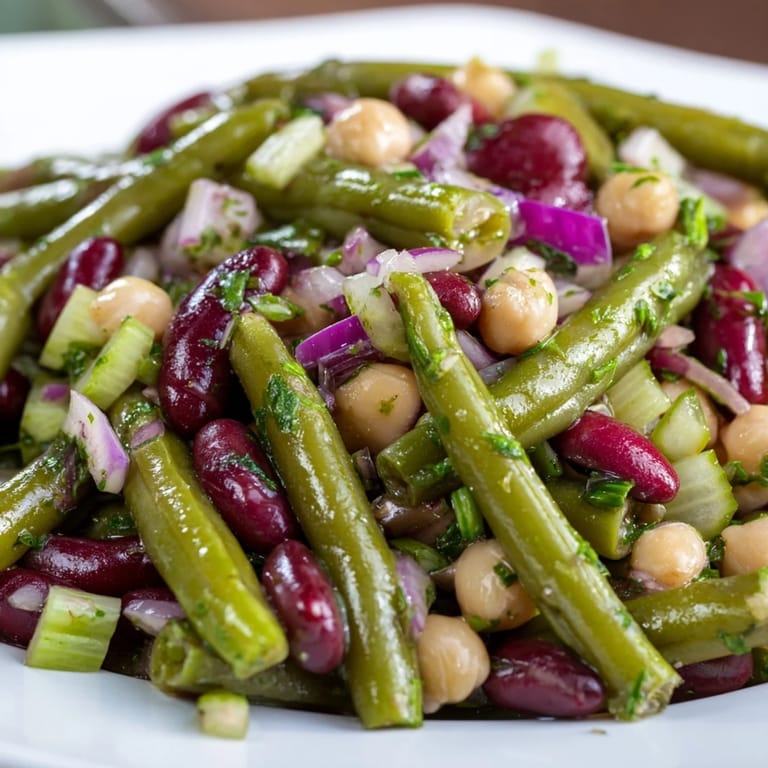 Chilled American-style Three-Bean Salad featuring a colorful medley of beans tossed in a sweet apple cider vinaigrette.