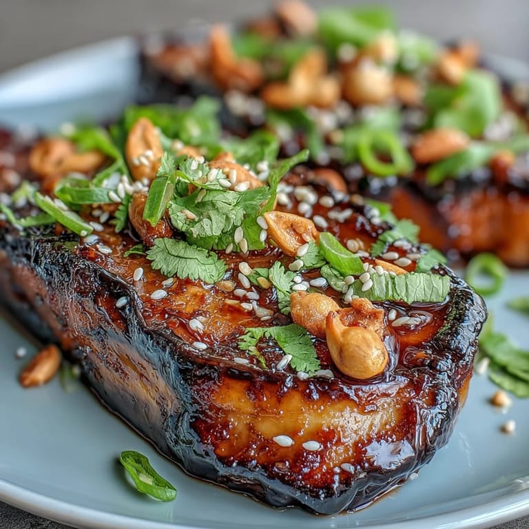 Thick eggplant slices roasted until golden, topped with a rich miso glaze and garnished with sesame seeds and green onions.  