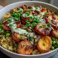 Warm quinoa bowl with roasted carrots and green peas, topped with fresh parsley and a tangy lemon dressing for a nourishing meal.
